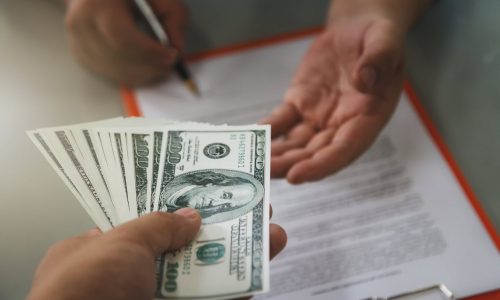 Man offering batch of hundred dollar bills. Close up of business man signing contract making a deal, business contract details.
